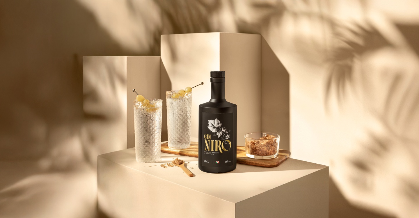 Niro Tonic in due bicchieri highball con ghiaccio e agrumi accanto alla bottiglia GIN NIRO